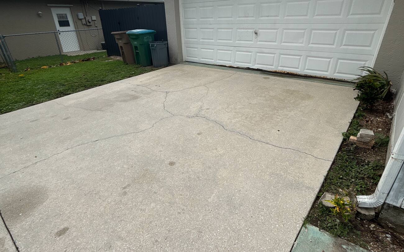 Driveway cleaning after in Cape Coral FL — freshly pressure washed concrete by J Property Services